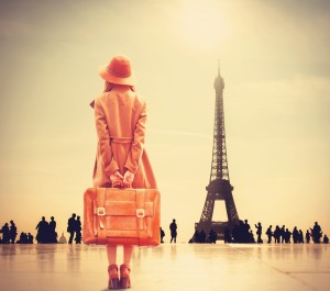 Redhead girl with suitcase on Eiffel tower background