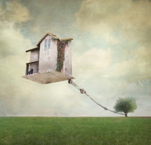 Artistic image representing an house floating in the air tied to a rope to the tree in a surreal vintage background
